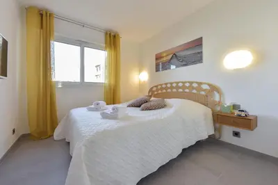 a bedroom with a white bed with towels on it at 3-Br Apartment 3 minutes to the Croisette in Cannes
