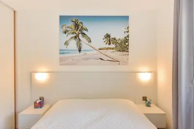 a bedroom with a bed and a picture of a beach at 3-Br Apartment 3 minutes to the Croisette in Cannes
