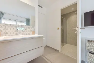 a bathroom with a sink and a shower and a television at 3-Br Apartment 3 minutes to the Croisette in Cannes