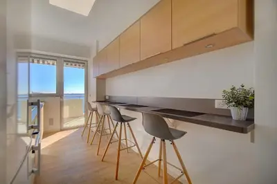 a kitchen with bar stools and a counter with a view at IMMOGROOM- Incredible View -4- Big Terrace - AC - Parking in Cannes