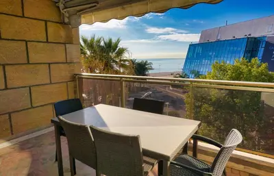 a table and chairs on a balcony with a view of the ocean at LEM5D - Palmes d'Or Properties in Cannes