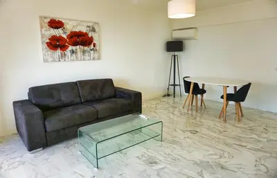 a living room with a couch and a table at LEM5D - Palmes d'Or Properties in Cannes