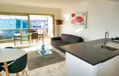 a kitchen and living room with a couch and a table at LEM5F - Palmes d'Or Properties in Cannes