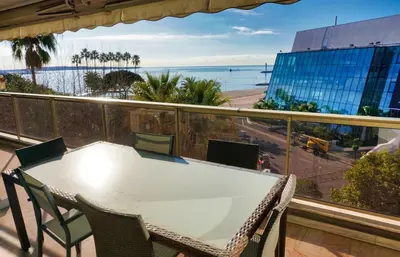 a table and chairs on a balcony with a view of the ocean at LEM5F - Palmes d'Or Properties in Cannes