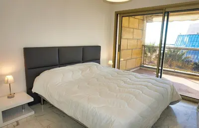 a bedroom with a large bed and a large window at LEM5F - Palmes d'Or Properties in Cannes