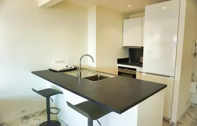 a kitchen with a sink and a black counter top at LEM5F - Palmes d'Or Properties in Cannes