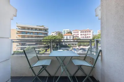a table and two chairs on a balcony with a view at LB Vacation Rentals I Cannes Center, Renovated Apartment with Balcony, Ideal for Holidays or Congress! in Cannes
