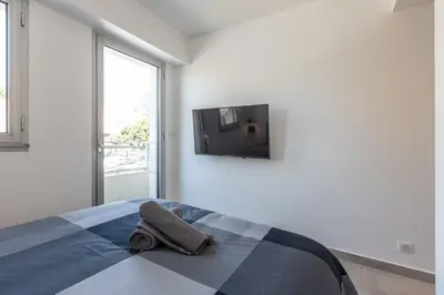 a bedroom with a bed with a towel on it at LB Vacation Rentals I Cannes Center, Renovated Apartment with Balcony, Ideal for Holidays or Congress! in Cannes