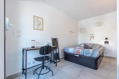a bedroom with a bed and a desk and a chair at LB Vacation Rentals I Cannes Center, Renovated Apartment with Balcony, Ideal for Holidays or Congress! in Cannes