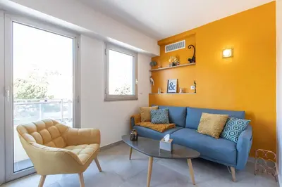 a living room with a blue couch and a table at LB Vacation Rentals I Cannes Center, Renovated Apartment with Balcony, Ideal for Holidays or Congress! in Cannes