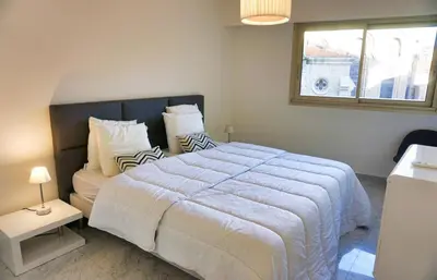 a bedroom with a large white bed and a window at Ref LEM4 - Palmes d'Or Properties in Cannes