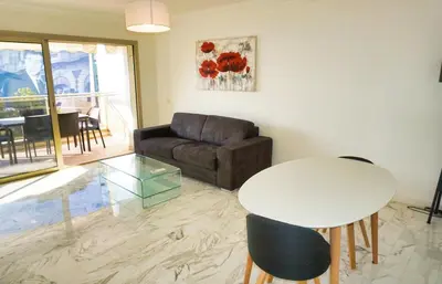 a living room with a table and a couch at Ref LEM4 - Palmes d'Or Properties in Cannes