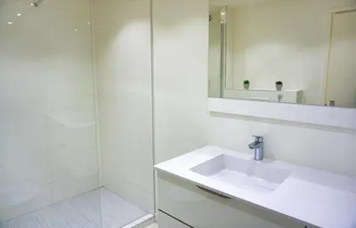a white bathroom with a sink and a shower at Ref LEM4 - Palmes d'Or Properties in Cannes