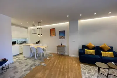 a living room with a blue couch and a kitchen at C016-Magnifique appartement de standing au coeur du Suquet in Cannes