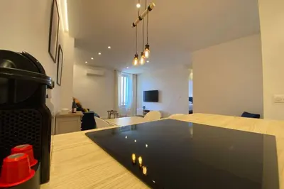a kitchen and living room with a laptop on a table at C016-Magnifique appartement de standing au coeur du Suquet in Cannes