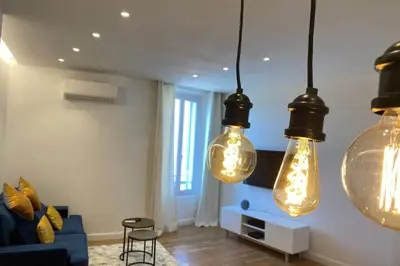 a living room with three lights hanging from the ceiling at C016-Magnifique appartement de standing au coeur du Suquet in Cannes