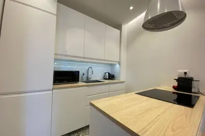a kitchen with white cabinets and a counter top at C016-Magnifique appartement de standing au coeur du Suquet in Cannes