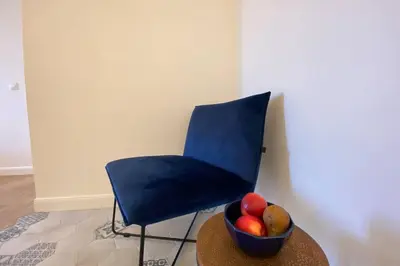 a blue chair and a bowl of fruit on a table at C016-Magnifique appartement de standing au coeur du Suquet in Cannes