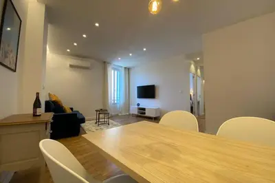 a living room with a wooden table and chairs at C016-Magnifique appartement de standing au coeur du Suquet in Cannes