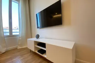 a white cabinet with a flat screen tv on a wall at C016-Magnifique appartement de standing au coeur du Suquet in Cannes