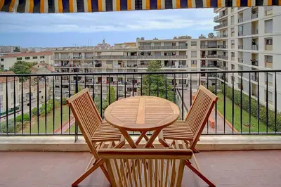 a wooden table and two chairs on a balcony at IMMOGROOM - Very Pleasant and Bright - Cozy - Shops in Cannes