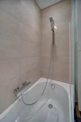 a white bath tub with a shower in a bathroom at IMMOGROOM - Very Pleasant and Bright - Cozy - Shops in Cannes