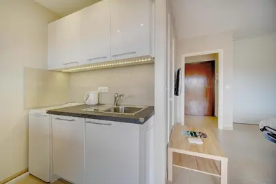 a small kitchen with white cabinets and a sink at IMMOGROOM - Very Pleasant and Bright - Cozy - Shops in Cannes