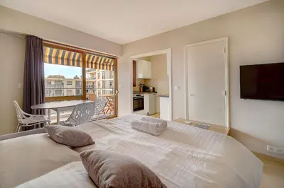 a bedroom with a large white bed and a balcony at IMMOGROOM - Very Pleasant and Bright - Cozy - Shops in Cannes