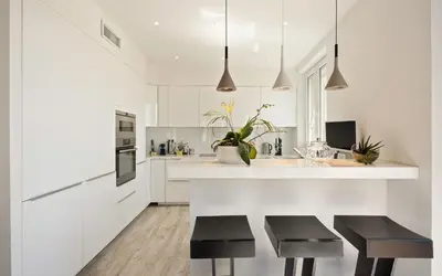 a kitchen with white cabinets and black stools at Duplex ForVille in Cannes