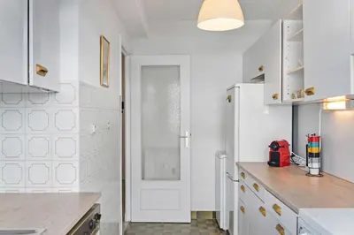 a kitchen with white cabinets and a white refrigerator at Majestic Apartment in Cannes