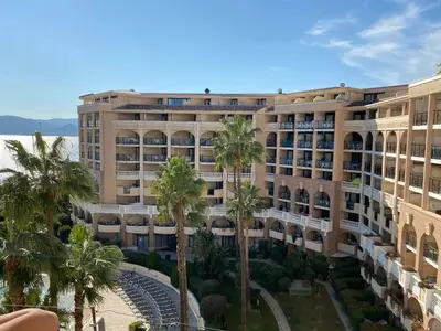 a large building with palm trees in front of it at Résidence La Palme d'Azur - Petersen App 610 in Cannes
