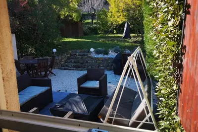 a living room with chairs and a table and a garden at Jolie petite Maison de Charme dans quartier boisé in Vallauris