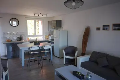 a kitchen and living room with a table and a couch at Jolie petite Maison de Charme dans quartier boisé in Vallauris