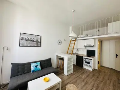 a living room with a couch and a small kitchen at Résidence 41 Léon Noel in Cannes