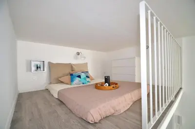 a white bedroom with a bed with a tray on it at Résidence 41 Léon Noel in Cannes