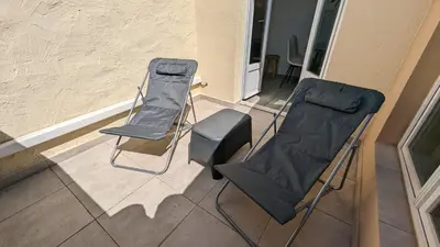 two folding chairs and a couch on a porch at Résidence 41 Léon Noel in Cannes