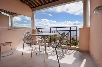 a balcony with a table and chairs and a view at Appartement Wester - Welkeys in Cannes