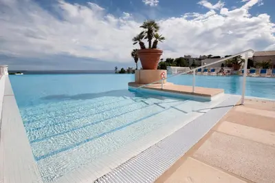 a swimming pool with a palm tree in the middle at Appartement Wester - Welkeys in Cannes