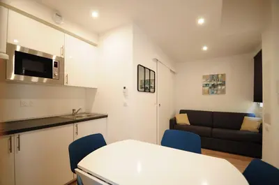 a kitchen and a living room with a couch at Résidence Delattre in Cannes