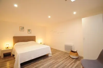 a bedroom with a white bed and a chair at Résidence Delattre in Cannes