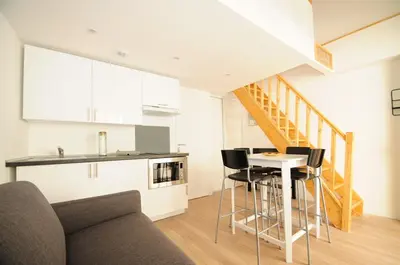 a kitchen and living room with a table and chairs at Résidence Delattre in Cannes