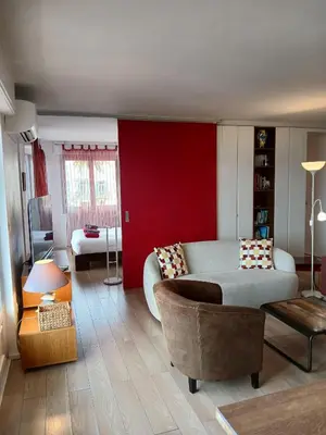 a bedroom with a large bed and a red wall at Plages du Midi, Superbe Vue Mer, Grand Confort, 4 pers in Cannes