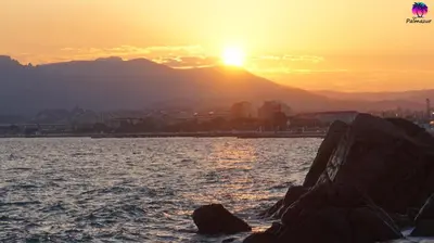 a sunset over a body of water with rocks at Appartement proche Croisette & Carlton By Palmazur in Cannes