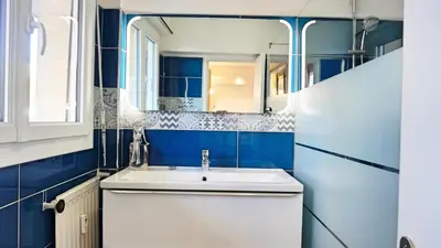 a blue bathroom with a sink and a mirror at Appartement proche Croisette & Carlton By Palmazur in Cannes