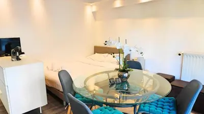 a room with a glass table with chairs and a bed at Appartement proche Croisette & Carlton By Palmazur in Cannes