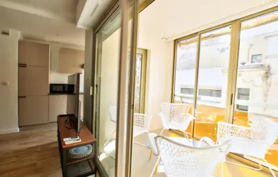 a living room with white chairs and a table at MAR2 - Beau 2 pièces avec loggia fermée et aménagée en centre ville in Cannes