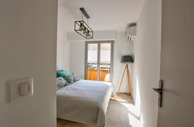 a bedroom with a bed and a window at MAR2 - Beau 2 pièces avec loggia fermée et aménagée en centre ville in Cannes