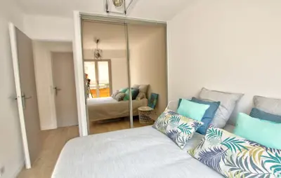 a bedroom with a bed and a large mirror at MAR2 - Beau 2 pièces avec loggia fermée et aménagée en centre ville in Cannes