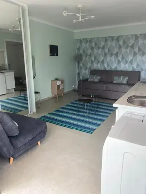 a living room with a couch and a living room with a table at Appartement rooftop, première ligne, vue mer, 50m de plage du Midi in Cannes