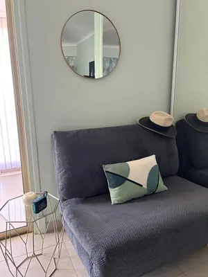 a living room with a couch and a mirror at Appartement rooftop, première ligne, vue mer, 50m de plage du Midi in Cannes